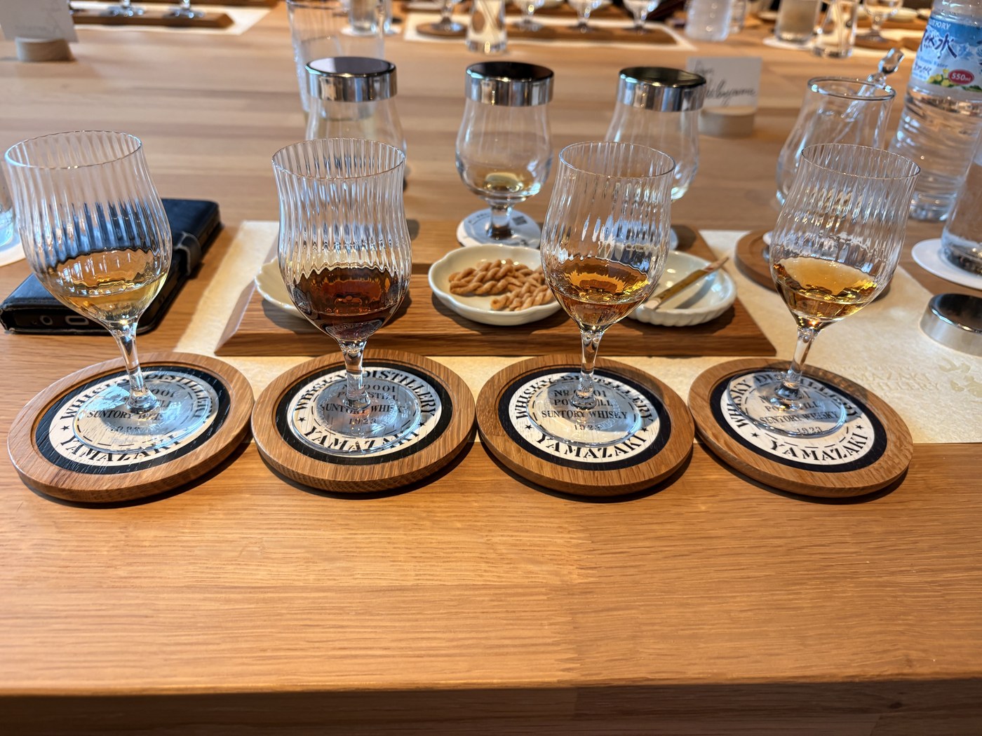 樽の鏡板をかたどったコースターに並ぶ原酒4杯